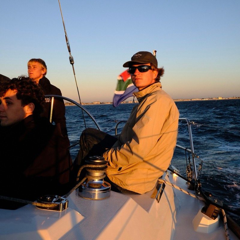 Willem at the helm at golden hour, South African flag flying